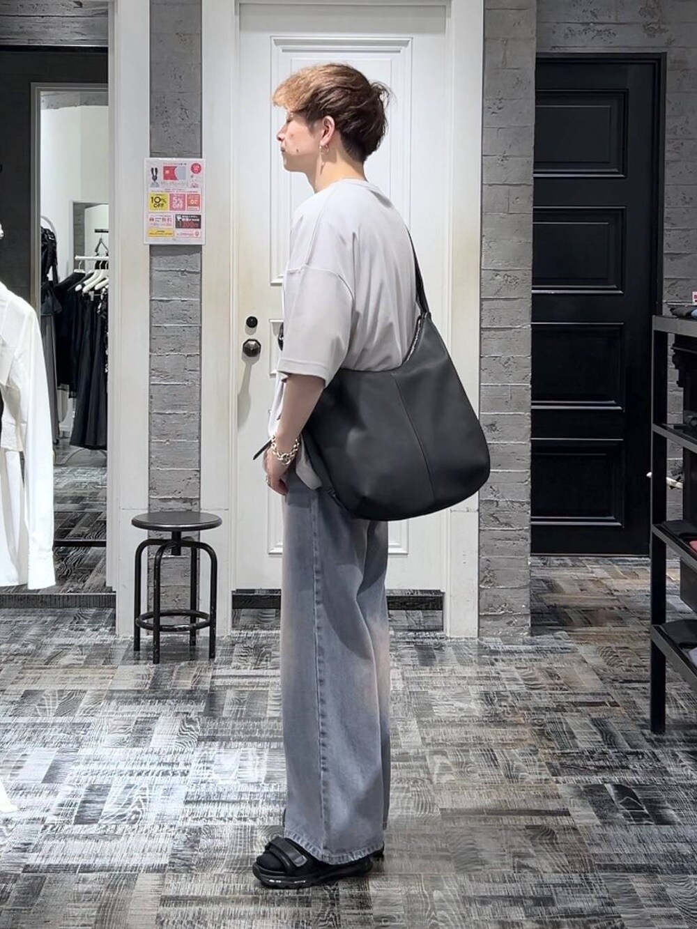 グレー系のTシャツ/カットソー、パープル系のデニムパンツ、ブラック系のサンダルを着用したメンズの夏コーディネートの2枚目の写真