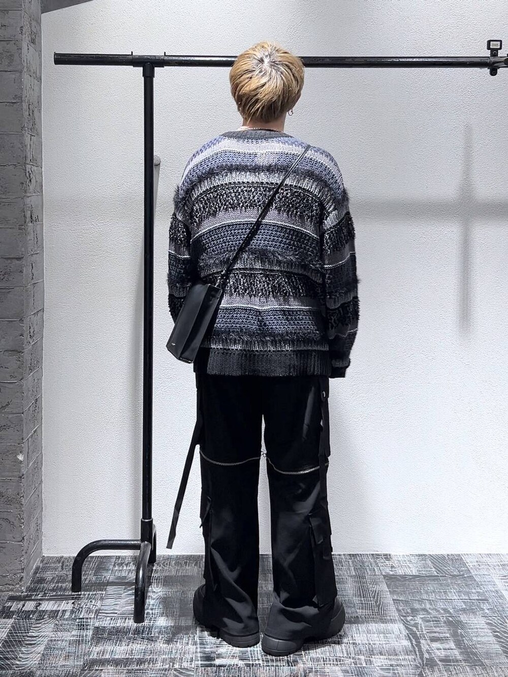 ブラック系のスニーカー、ブラック系のショルダーバッグ、ブラック系のニット/セーターを着用したメンズの春コーディネートの3枚目の写真