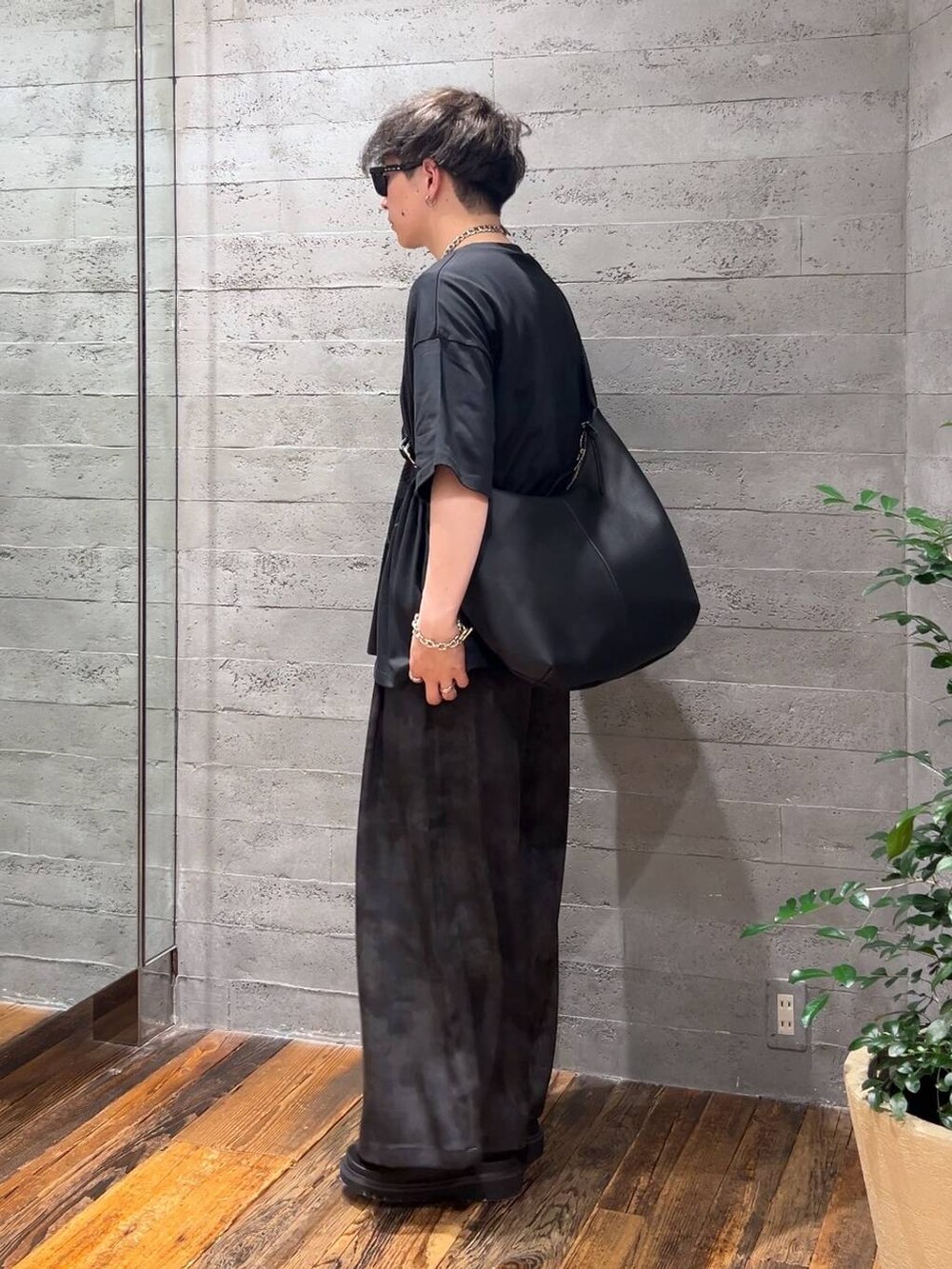 ブラック系のサンダル、グレー系のスラックス、ブラック系のTシャツ/カットソーを着用したメンズの夏コーディネートの4枚目の写真