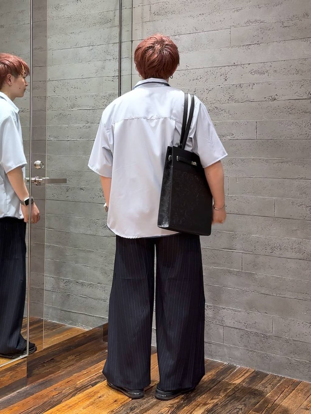 ブラック系のサンダル、ブラック系のTシャツ/カットソー、ブルー系のスラックスを着用したメンズの夏コーディネートの3枚目の写真