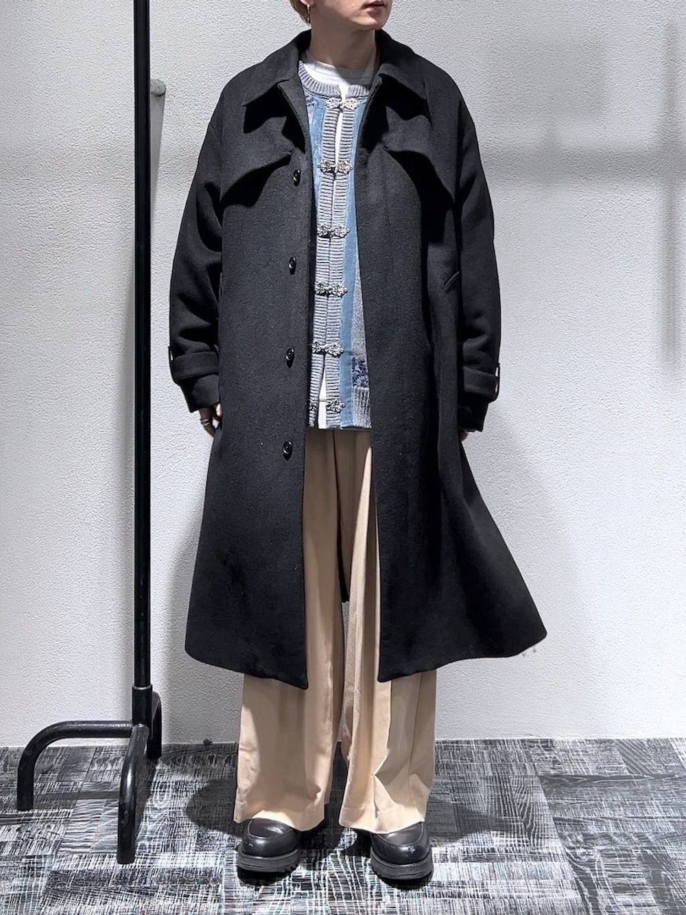 ブラック系のステンカラーコート、ブラック系のドレスシューズ、グレー系のスウェットを着用したメンズの冬コーディネートの2枚目の写真