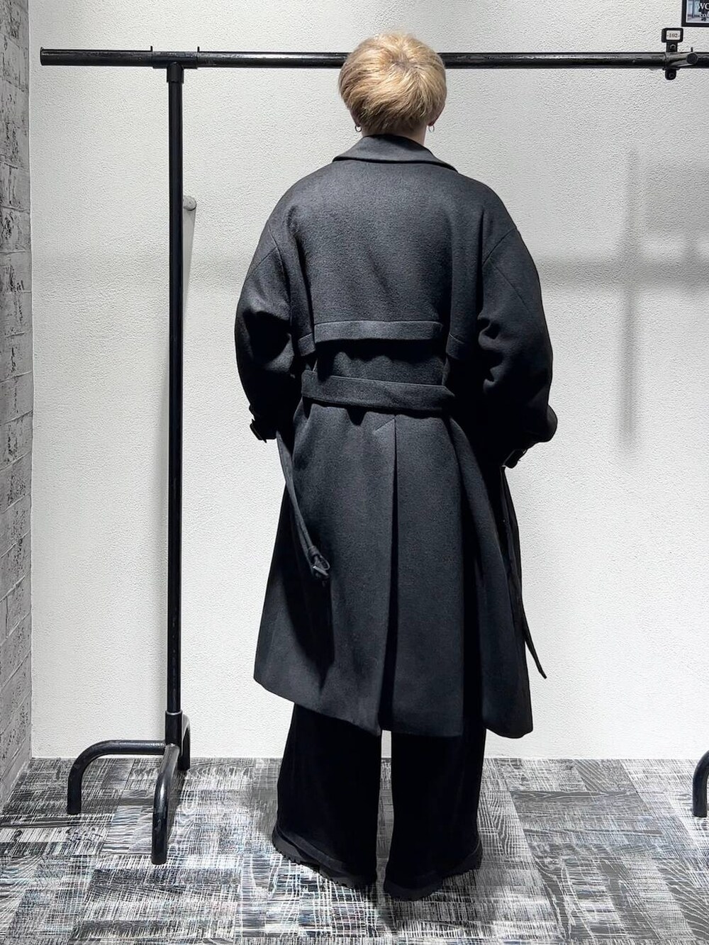 ブラック系のデニムパンツ、ブラック系のステンカラーコート、ブラック系のショルダーバッグを着用したメンズの秋コーディネートの4枚目の写真