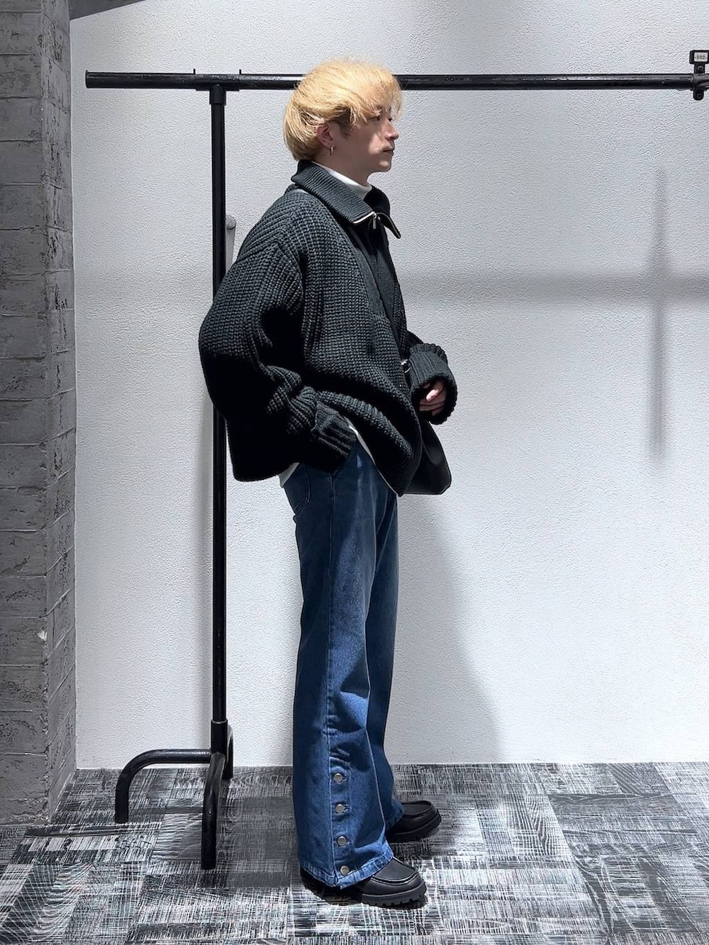 ブルー系のデニムパンツ、ブラック系のショルダーバッグ、ブラック系のドレスシューズを着用したメンズの冬コーディネートの3枚目の写真