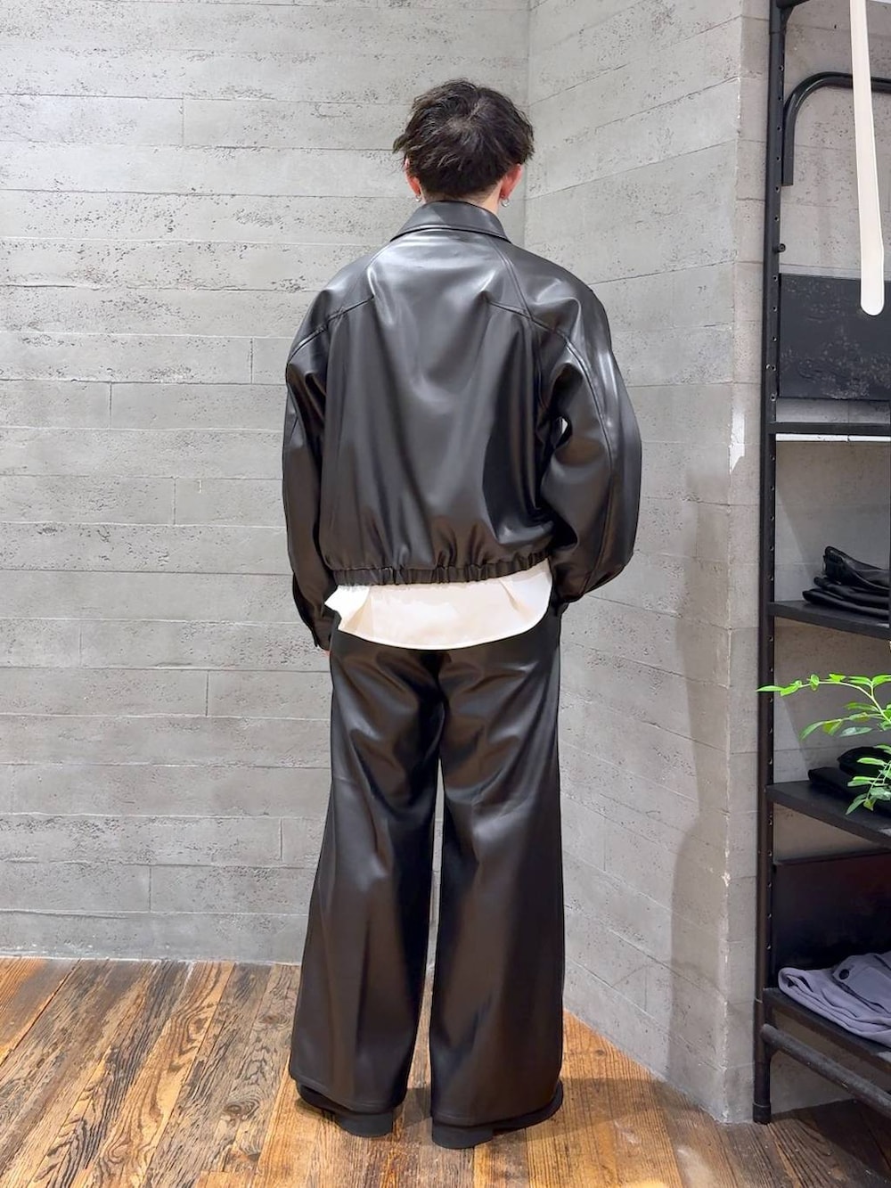 ブラック系のブルゾン、ブラック系のスラックス、ブラック系のローファーを着用したメンズの夏コーディネートの3枚目の写真