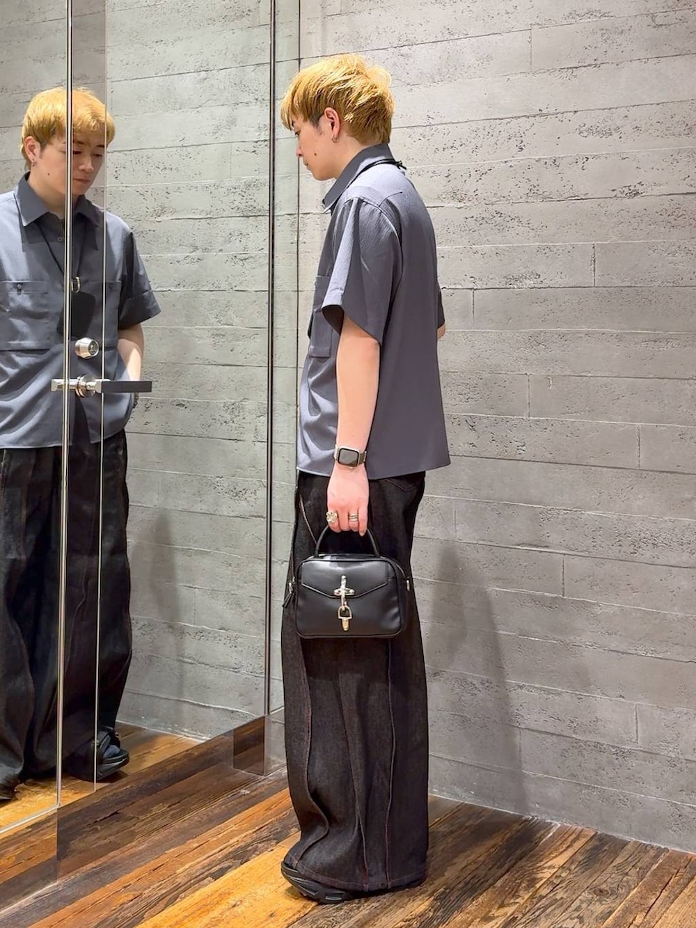 ブラック系のサンダル、ブラック系のデニムパンツ、ブラック系のショルダーバッグを着用したメンズの春コーディネートの4枚目の写真