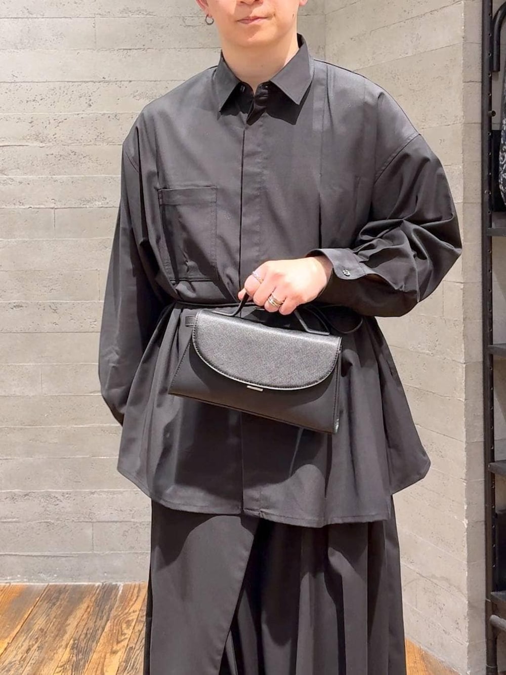 ブラック系のスニーカー、ブラック系のスラックス、ブラック系のショルダーバッグを着用したメンズの冬コーディネートの5枚目の写真