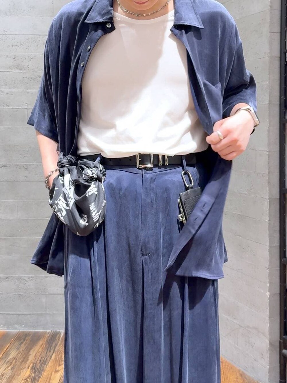 ブルー系のスラックス、ブラック系のサンダル、ホワイト系のTシャツ/カットソーを着用したメンズの夏コーディネートの5枚目の写真
