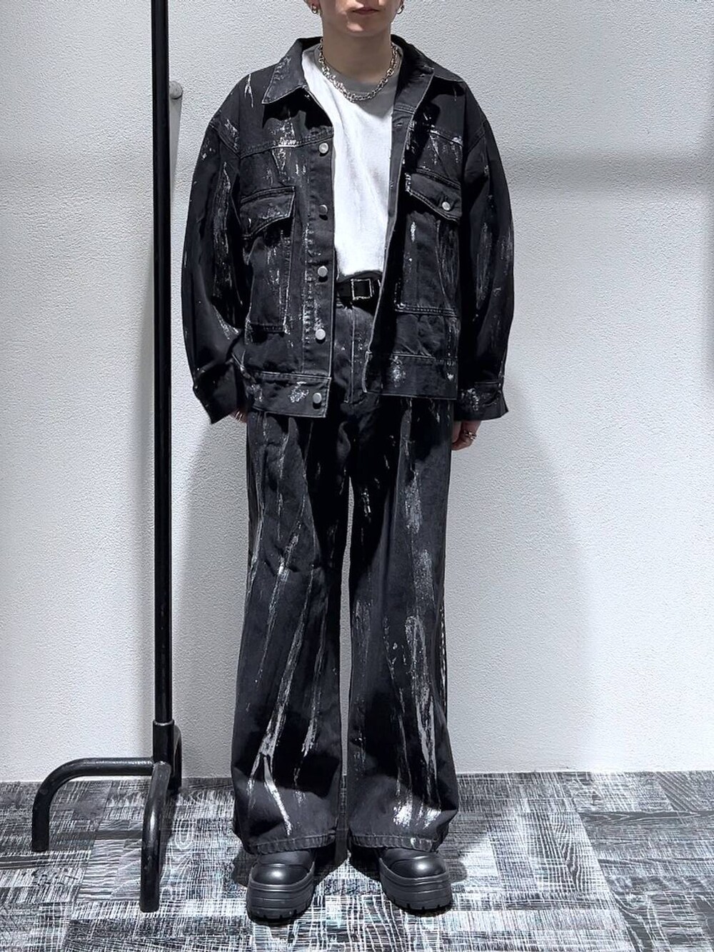 グレー系のスウェット、ブラック系のブーツ、ブラック系のデニムジャケットを着用したメンズの冬コーディネートの2枚目の写真