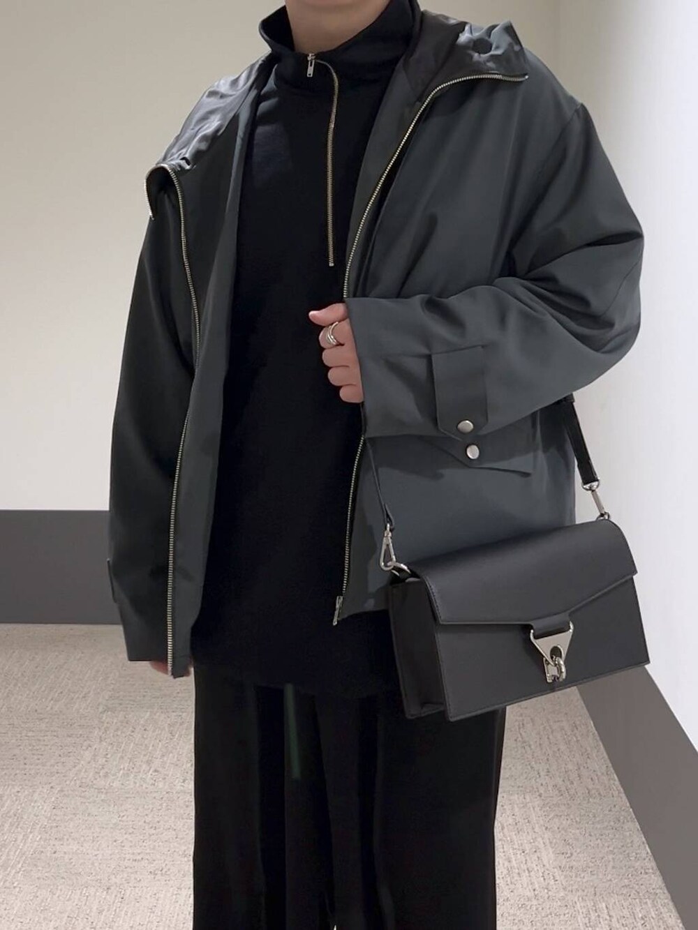 ブラック系のスラックス、ブラック系のショルダーバッグ、ブラック系のドレスシューズを着用したメンズの冬コーディネートの5枚目の写真