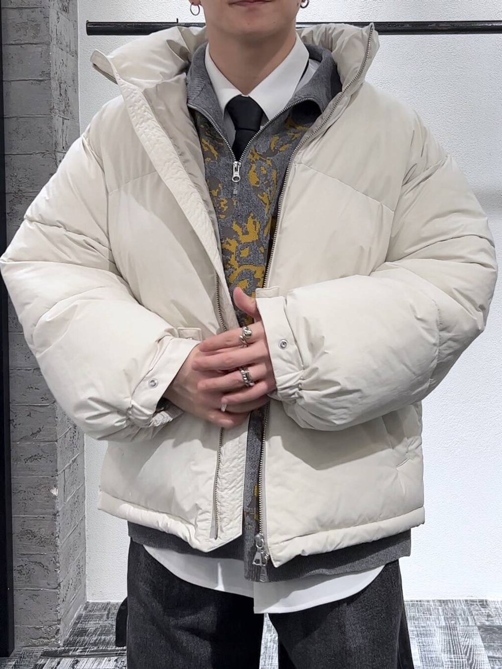 ホワイト系のダウンジャケット/コート、ブラック系のデニムパンツ、ブラック系のネクタイを着用したメンズの秋コーディネートの4枚目の写真