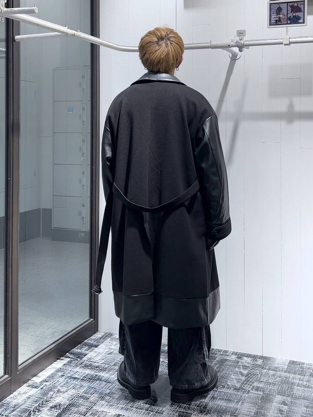 ブラック系のトレンチコート、ブラック系のその他シューズ、グレー系のニット/セーターを着用したメンズの秋コーディネートの3枚目の写真