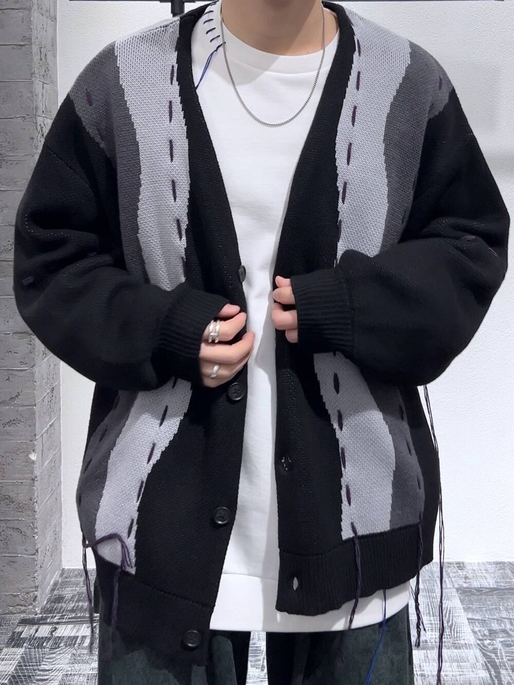 ブラック系のドレスシューズ、ブラック系のカーディガン/ボレロ、グリーン系のデニムパンツを着用したメンズの冬コーディネートの5枚目の写真