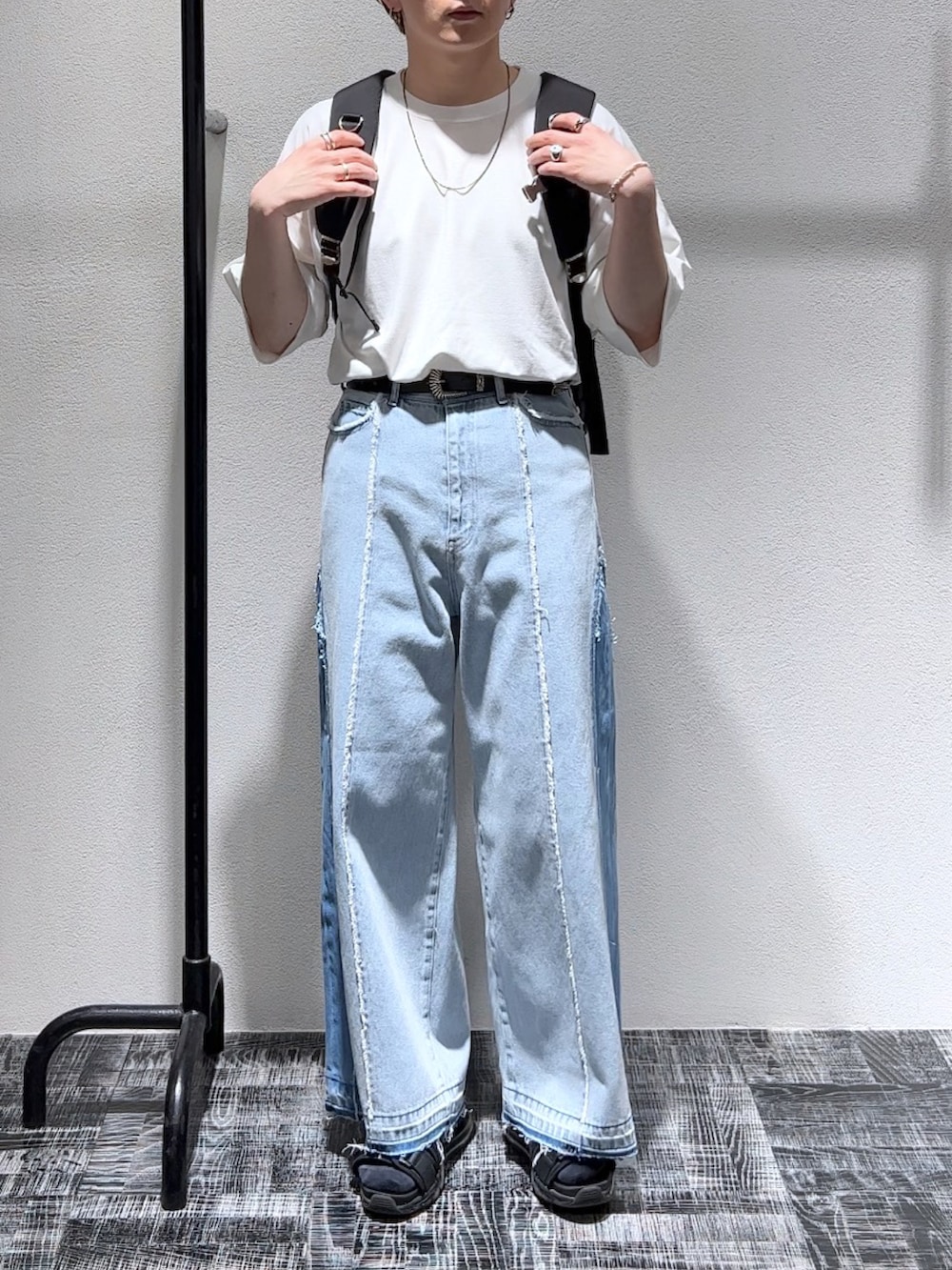 ホワイト系のTシャツ/カットソー、ブルー系のデニムパンツ、ブラック系のバックパック/リュックを着用したメンズの春コーディネートの2枚目の写真