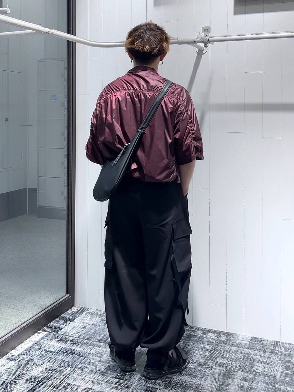 ブラック系のショルダーバッグ、ブラック系のサンダル、グレー系のTシャツ/カットソーを着用したメンズの夏コーディネートの2枚目の写真