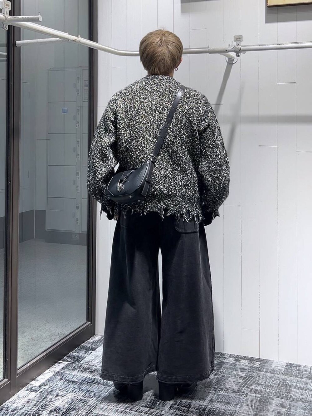 ブラック系のブーツ、ブラック系のTシャツ/カットソー、ブラック系のショルダーバッグを着用したメンズの冬コーディネートの3枚目の写真