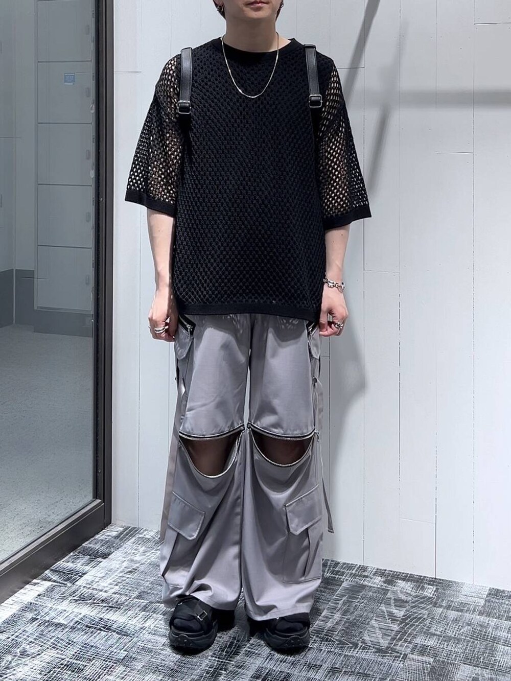 ブラック系のニット/セーター、グレー系のカーゴパンツ、ブラック系のTシャツ/カットソーを着用したメンズの春コーディネートの2枚目の写真