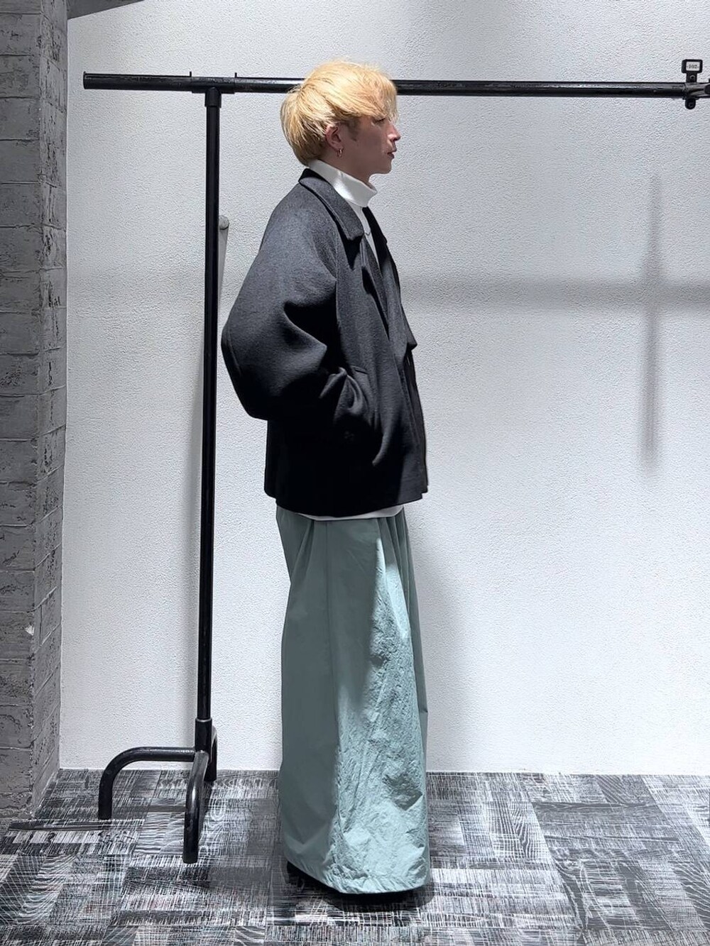 ブラック系のブルゾン、ブラック系のブーツ、ホワイト系のスウェットを着用したメンズの秋コーディネートの3枚目の写真