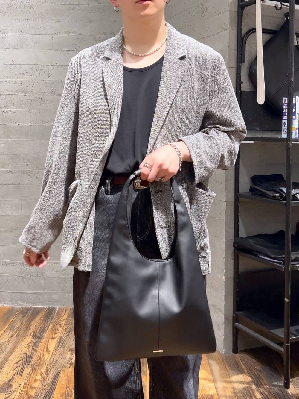 ブラック系のトートバッグ、ブラック系のサンダル、ブラック系のデニムパンツを着用したメンズの夏コーディネートの5枚目の写真
