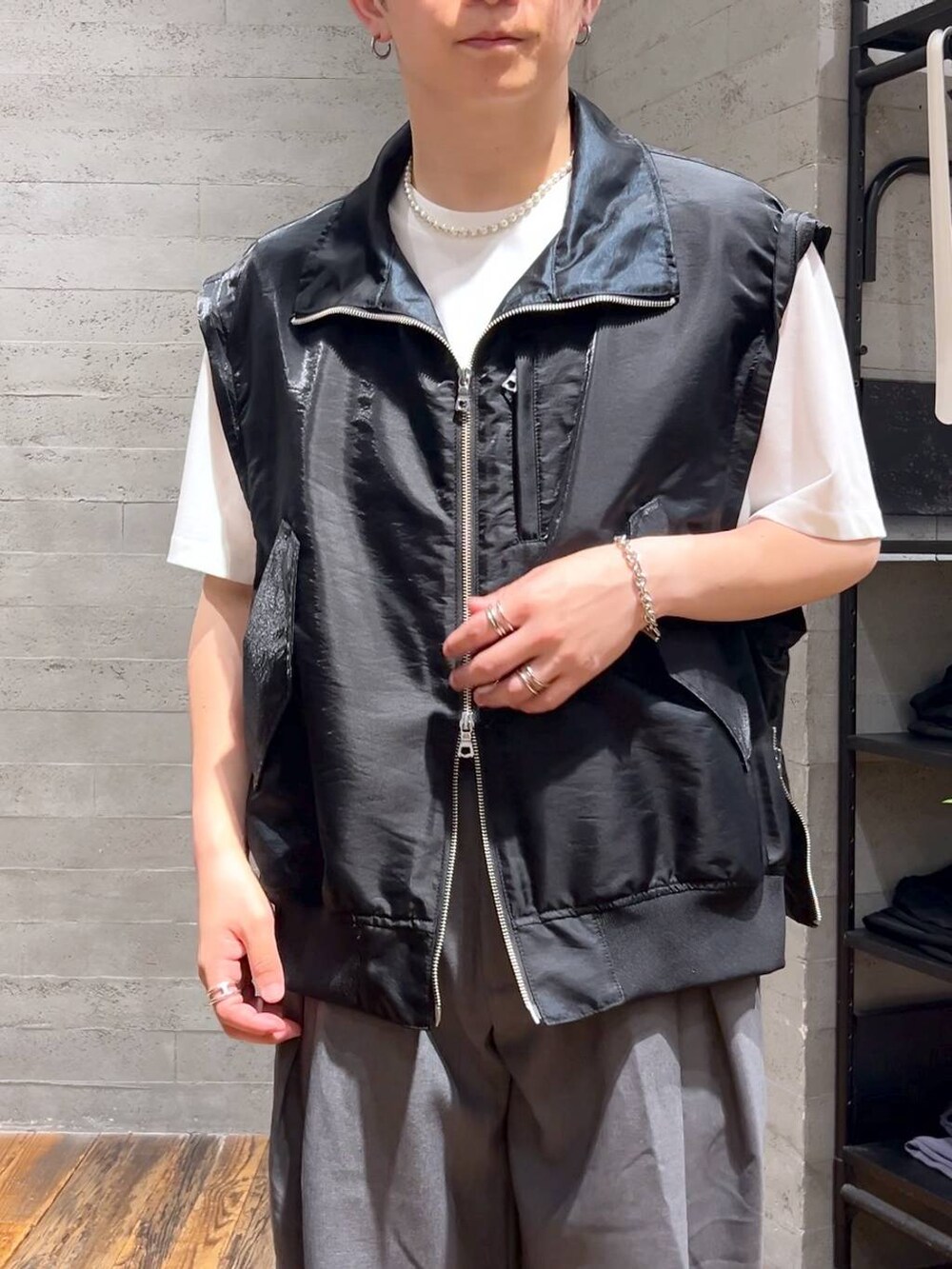 ホワイト系のTシャツ/カットソー、ブラック系のローファー、グレー系のスラックスを着用したメンズの夏コーディネートの5枚目の写真