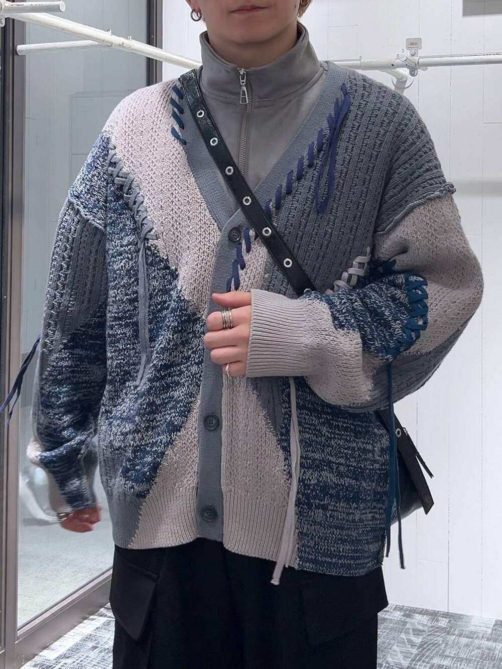 グレー系のカーディガン/ボレロ、グレー系のスウェット、ブラック系のカーゴパンツを着用したメンズの冬コーディネートの5枚目の写真