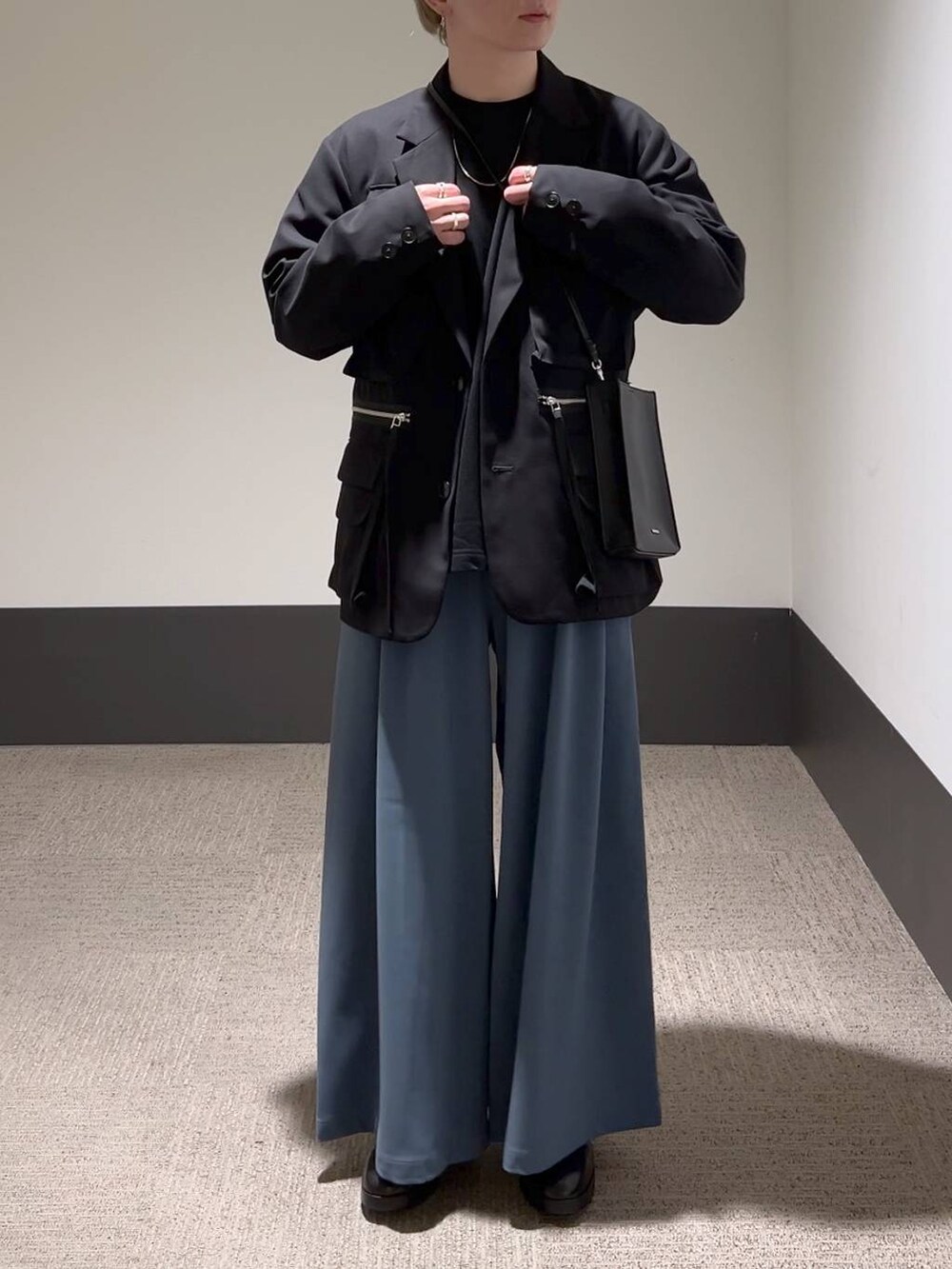 ブラック系のテーラードジャケット、ブラック系のTシャツ/カットソー、ブラック系のショルダーバッグを着用したメンズの冬コーディネートの2枚目の写真