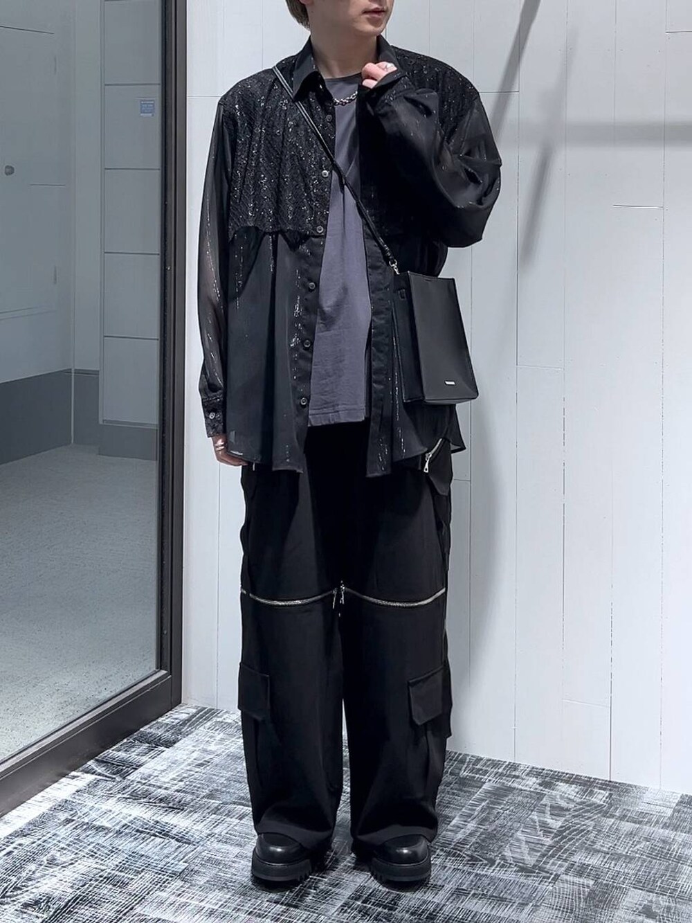 ブラック系のカーゴパンツ、ブラック系のショルダーバッグ、ブラック系のドレスシューズを着用したメンズの春コーディネートの2枚目の写真