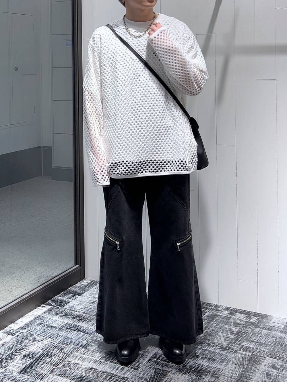 ブラック系のショルダーバッグ、ブラック系のデニムパンツ、ブラック系のドレスシューズを着用したメンズの春コーディネートの2枚目の写真