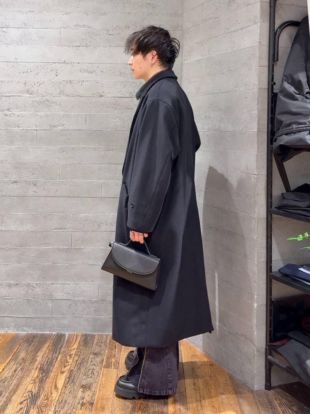 ブラック系のステンカラーコート、ブラック系のドレスシューズ、ブラック系のショルダーバッグを着用したメンズの冬コーディネートの4枚目の写真