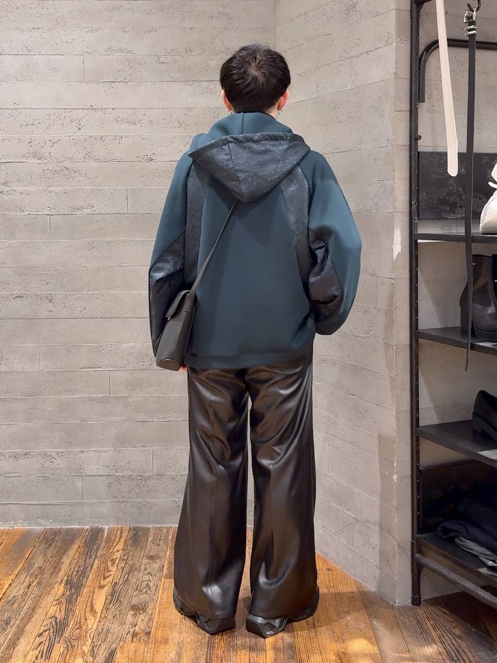 ブラック系のスラックス、ブラック系のスニーカー、ブラック系のショルダーバッグを着用したメンズの秋コーディネートの3枚目の写真