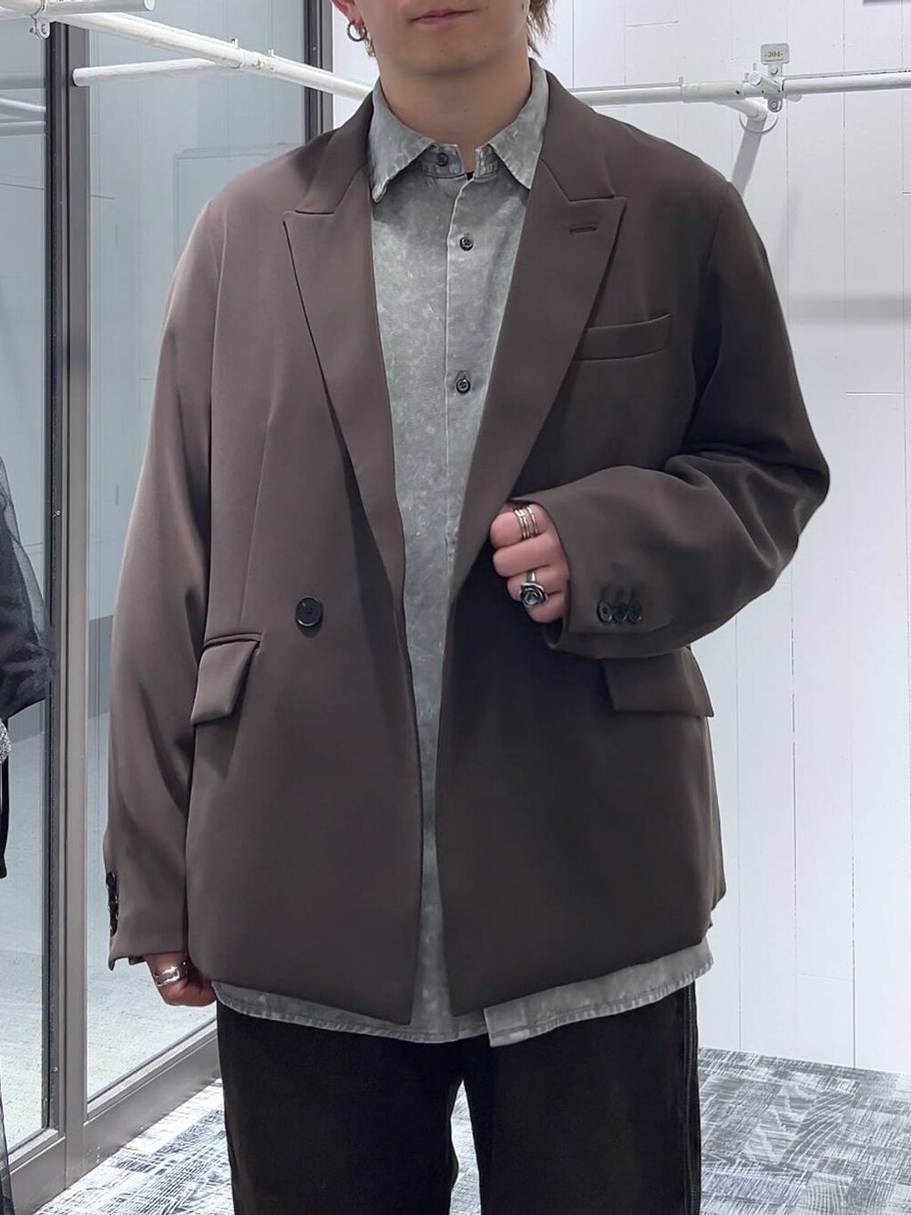 オレンジ系のデニムパンツ、ブラウン系のテーラードジャケット、ブラック系のドレスシューズを着用したメンズの春コーディネートの5枚目の写真