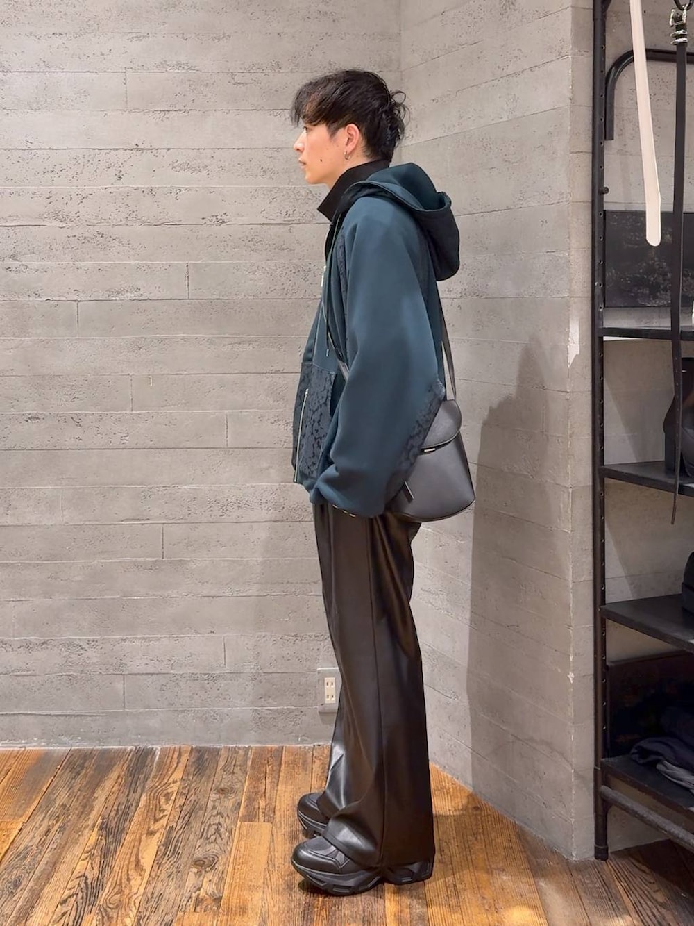 ブラック系のスラックス、ブラック系のスニーカー、ブラック系のショルダーバッグを着用したメンズの秋コーディネートの4枚目の写真