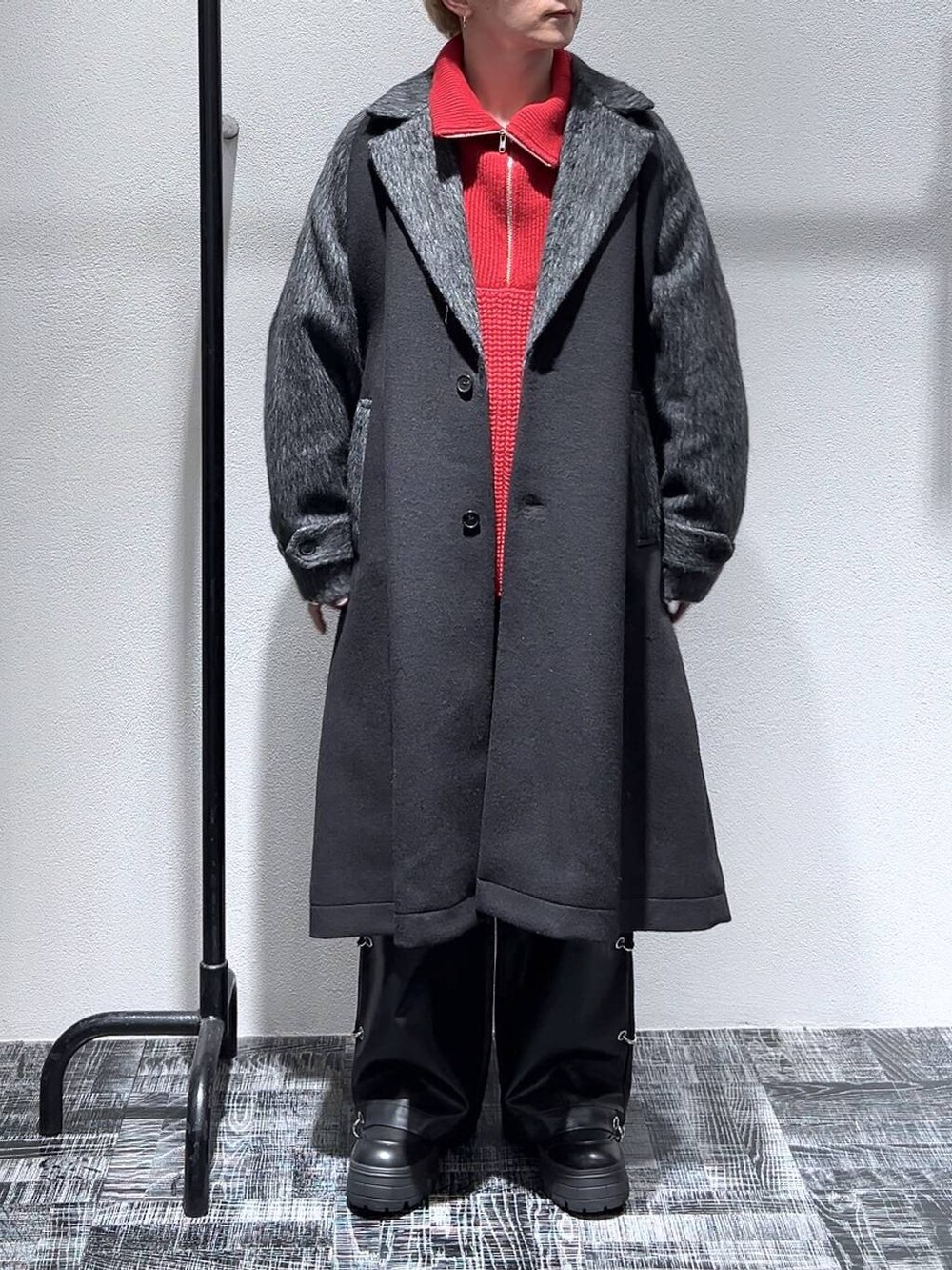 ブラック系のブーツ、ブラック系のダッフルコート、レッド系のニット/セーターを着用したメンズの秋コーディネートの2枚目の写真