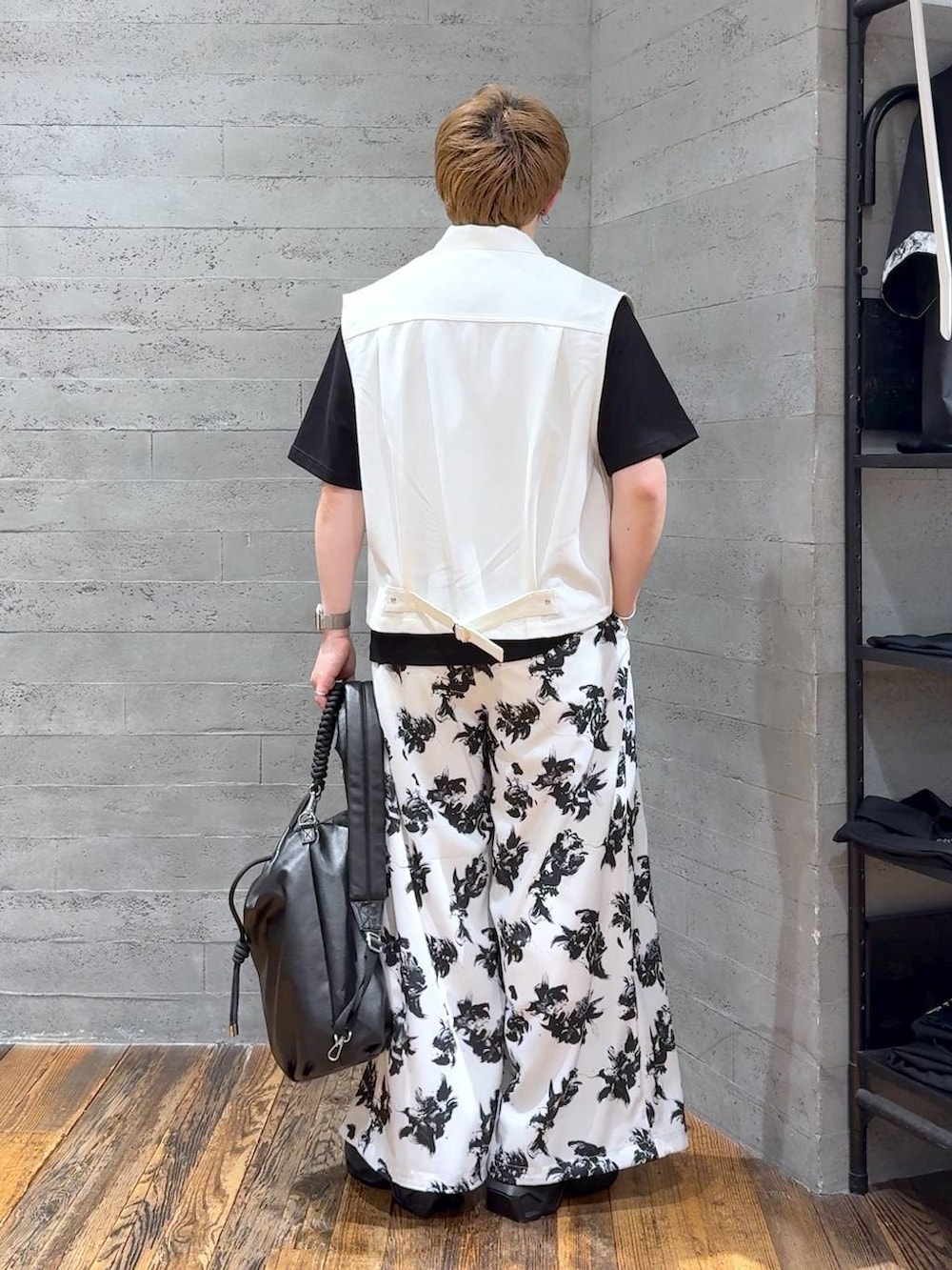 ブラック系のTシャツ/カットソー、ブラック系のサンダル、ホワイト系のスラックスを着用したメンズの夏コーディネートの3枚目の写真