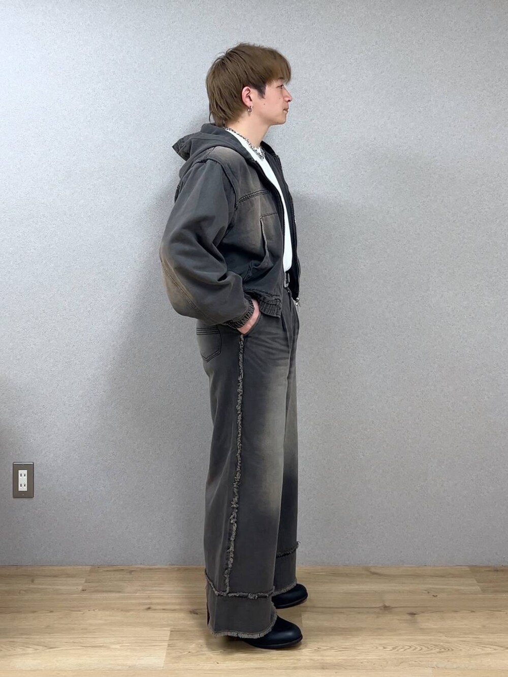 ブラウン系のデニムパンツ、ブラック系のドレスシューズ、シルバー系のネックレスを着用したメンズの冬コーディネートの2枚目の写真