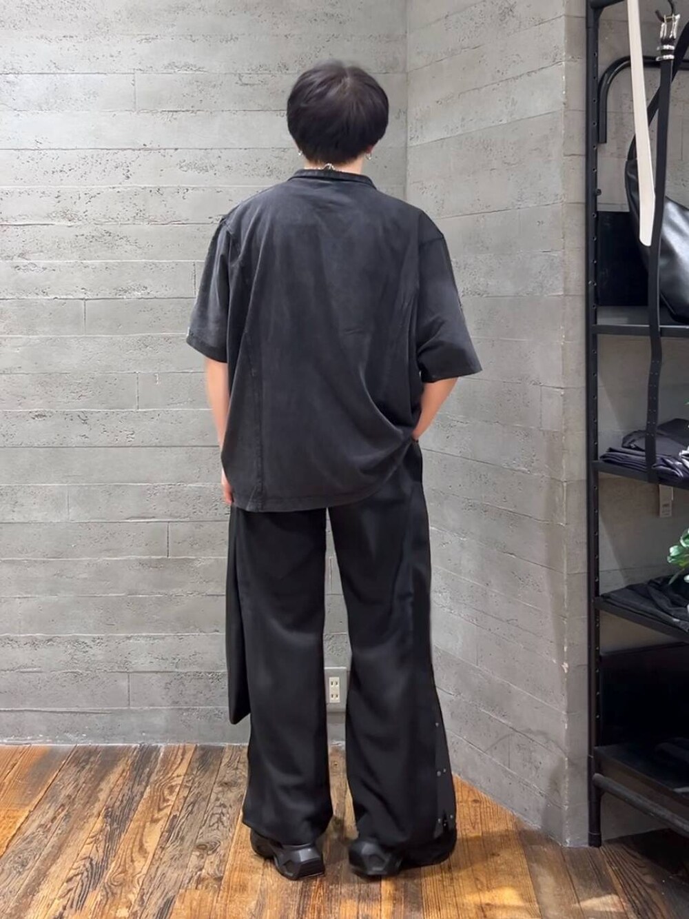 ブラック系のトートバッグ、ブラック系のサンダル、ブラック系のTシャツ/カットソーを着用したメンズの春コーディネートの3枚目の写真