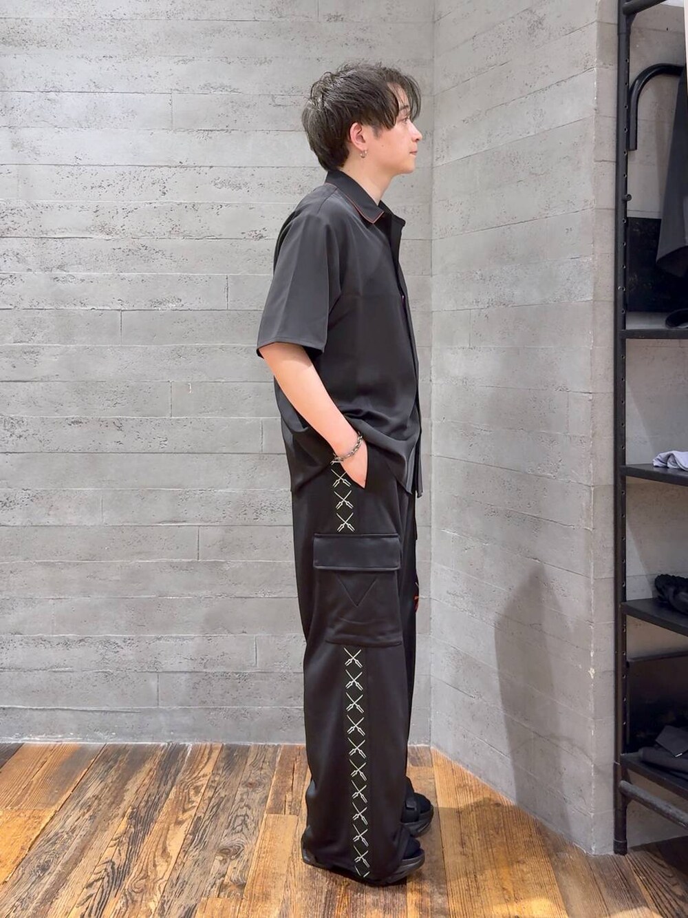 ブラック系のカーゴパンツ、レッド系のシャツ/ブラウス、ブラック系のサンダルを着用したメンズの夏コーディネートの2枚目の写真