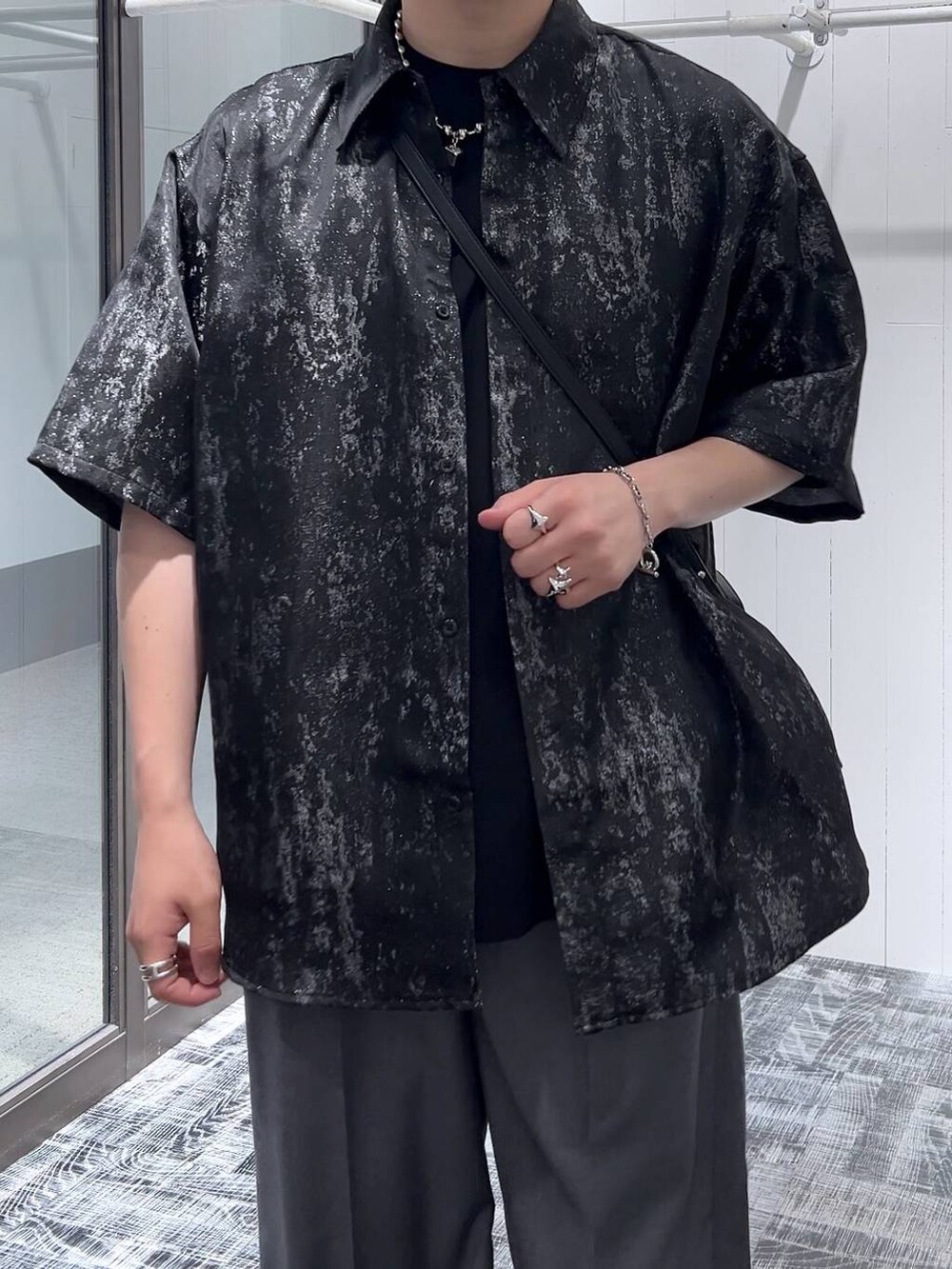 グレー系のスラックス、ブラック系のショルダーバッグ、ブラック系のサンダルを着用したメンズの夏コーディネートの5枚目の写真