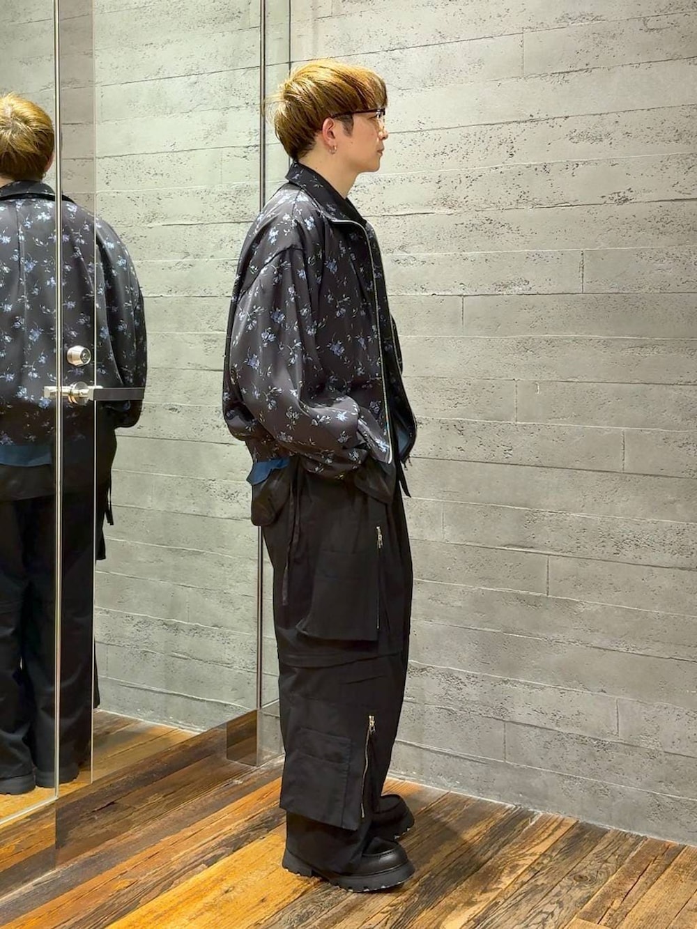 ブラック系のドレスシューズ、ブラック系のブルゾン、ブラック系のカーゴパンツを着用したメンズの春コーディネートの2枚目の写真