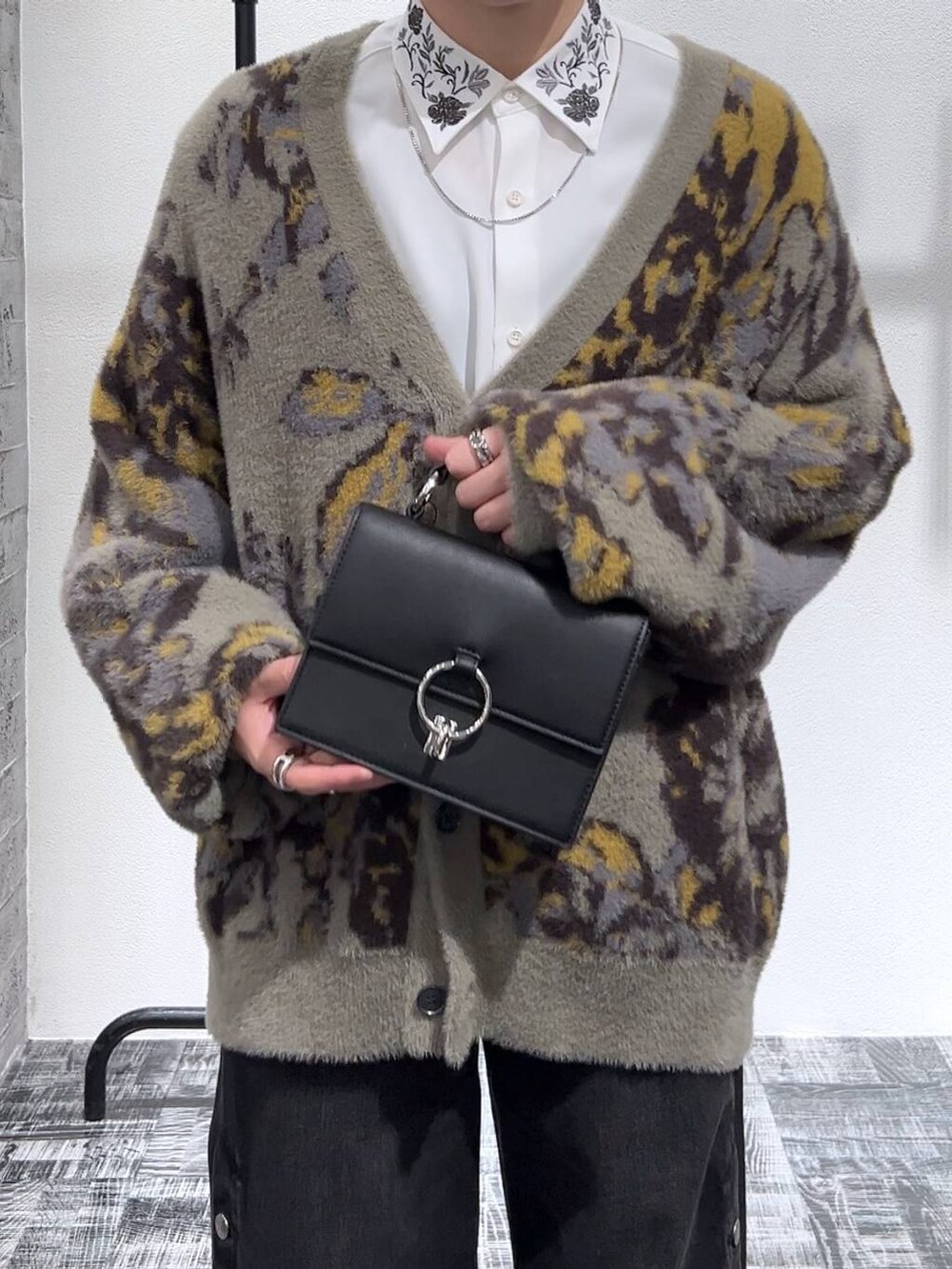 ブラック系のショルダーバッグ、グレー系のカーディガン/ボレロ、ブラック系のブーツを着用したメンズの冬コーディネートの5枚目の写真