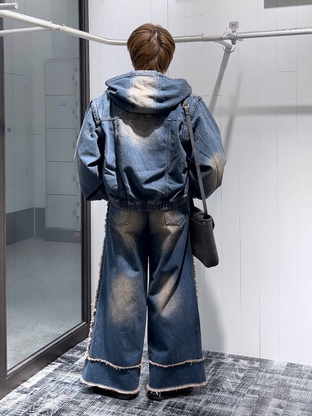 ブルー系のデニムパンツ、グレー系のショルダーバッグ、ホワイト系のTシャツ/カットソーを着用したメンズの冬コーディネートの3枚目の写真