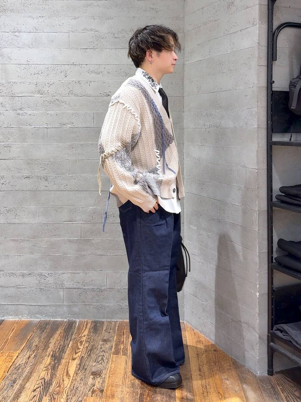 ブルー系のデニムパンツ、ホワイト系のシャツ/ブラウス、ブラック系のトートバッグを着用したメンズの秋コーディネートの2枚目の写真