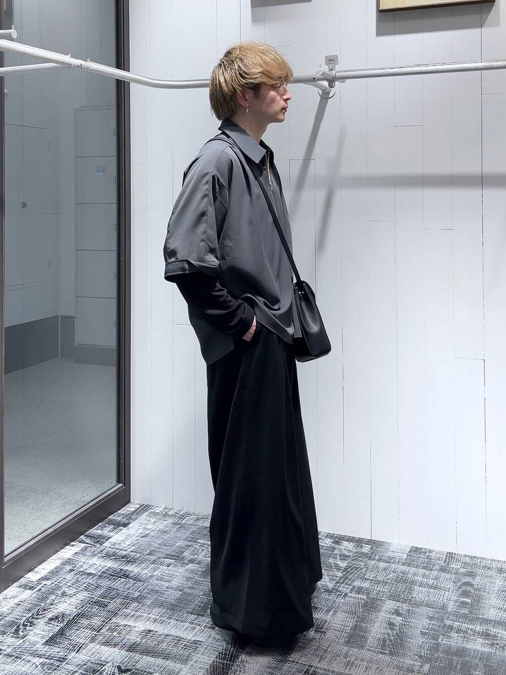 ブラック系のTシャツ/カットソー、ブラック系のショルダーバッグ、ブラック系のスラックスを着用したメンズの春コーディネートの3枚目の写真