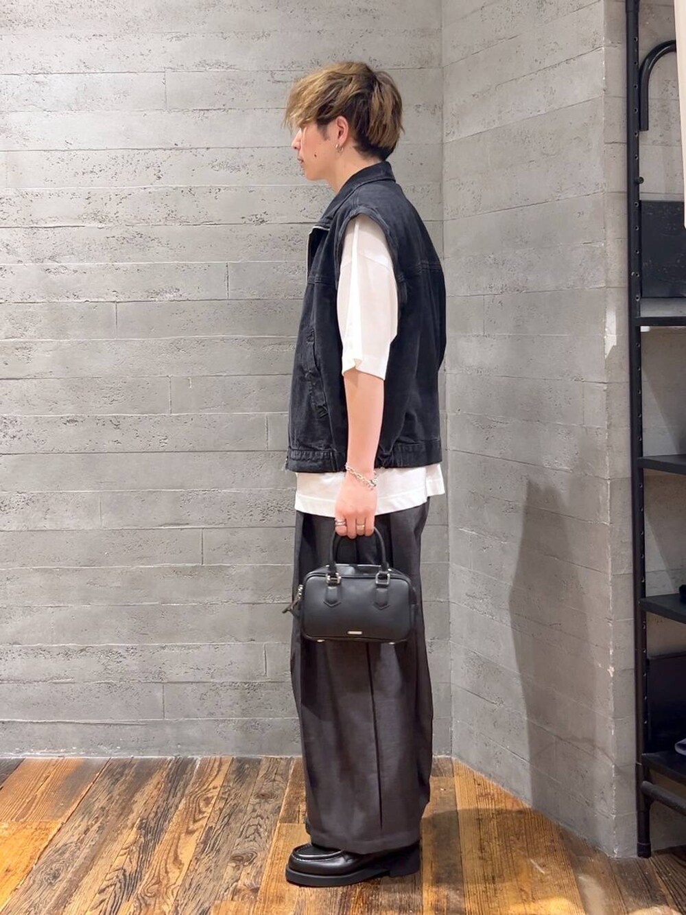 ブラック系のスラックス、ブラック系のローファー、ホワイト系のTシャツ/カットソーを着用したメンズの夏コーディネートの4枚目の写真