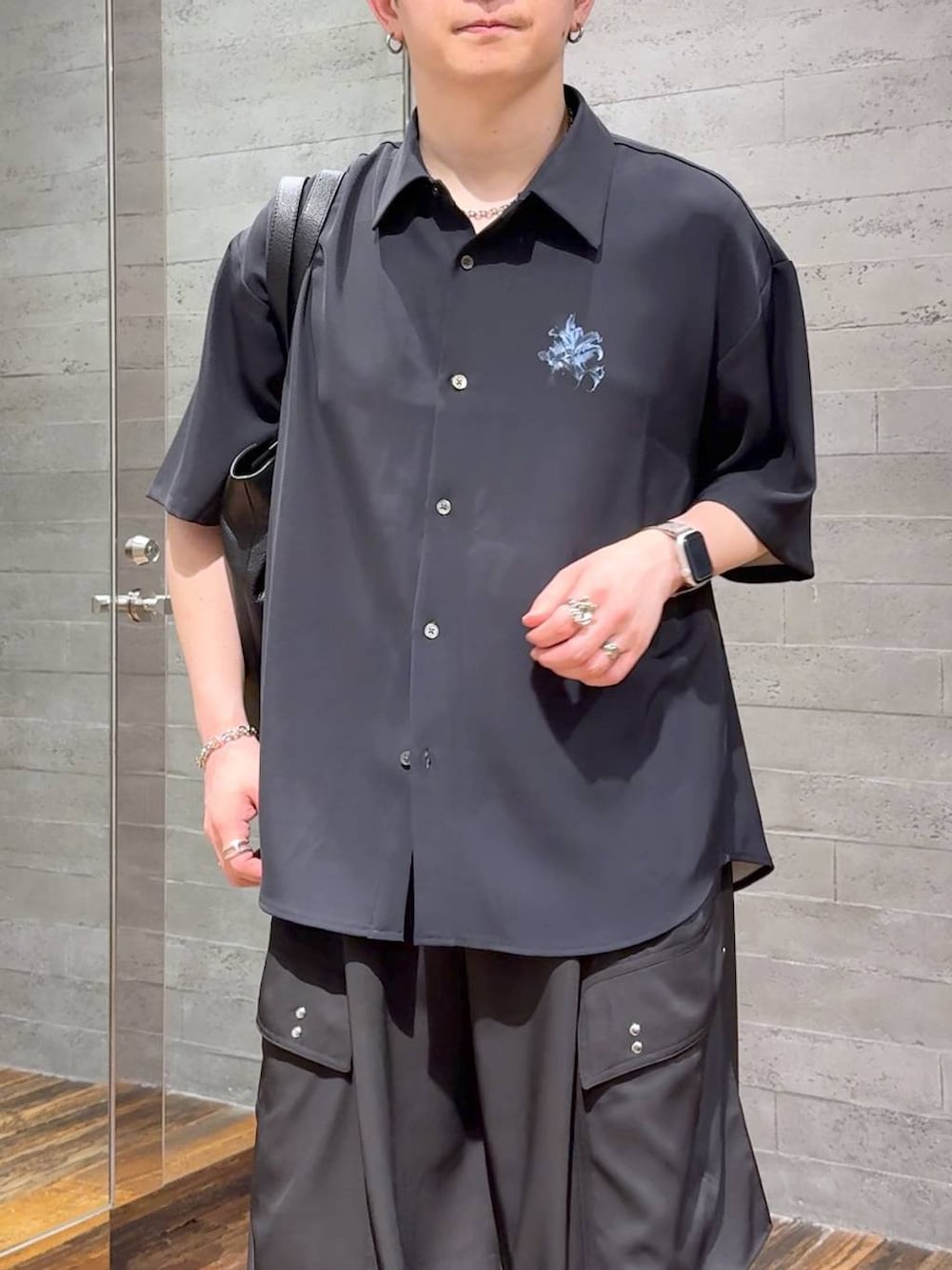 ブラック系のカーゴパンツ、ブラック系のトートバッグ、ブラック系のサンダルを着用したメンズの春コーディネートの5枚目の写真