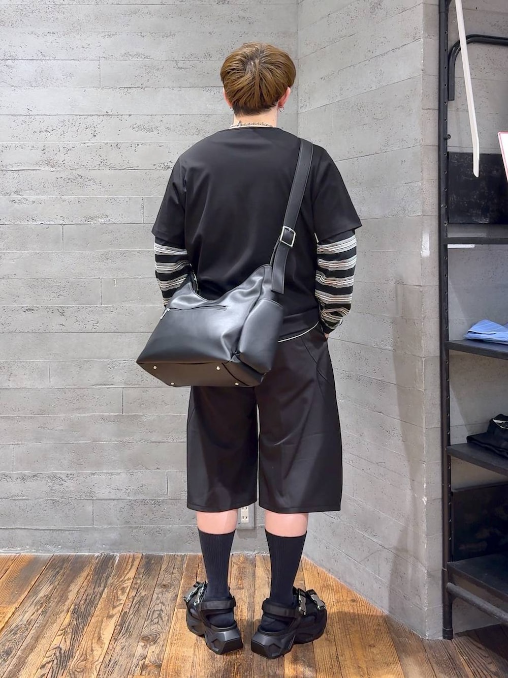 ブラック系のサンダル、ブラック系のショルダーバッグ、ブラック系のスラックスを着用したメンズの春コーディネートの3枚目の写真