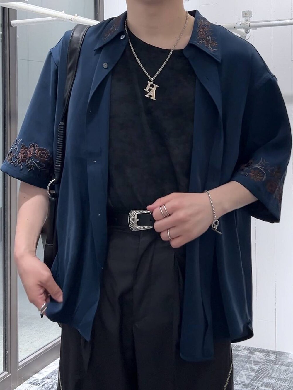 ブラック系のスラックス、ブラック系のサンダル、グレー系のTシャツ/カットソーを着用したメンズの春コーディネートの5枚目の写真