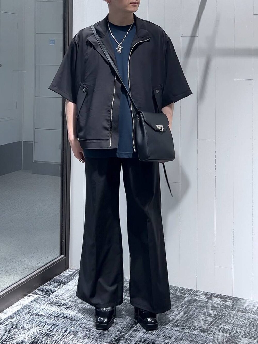 ブラック系のドレスシューズ、ブラック系のショルダーバッグ、ブラック系のシャツ/ブラウスを着用したメンズの夏コーディネートの2枚目の写真