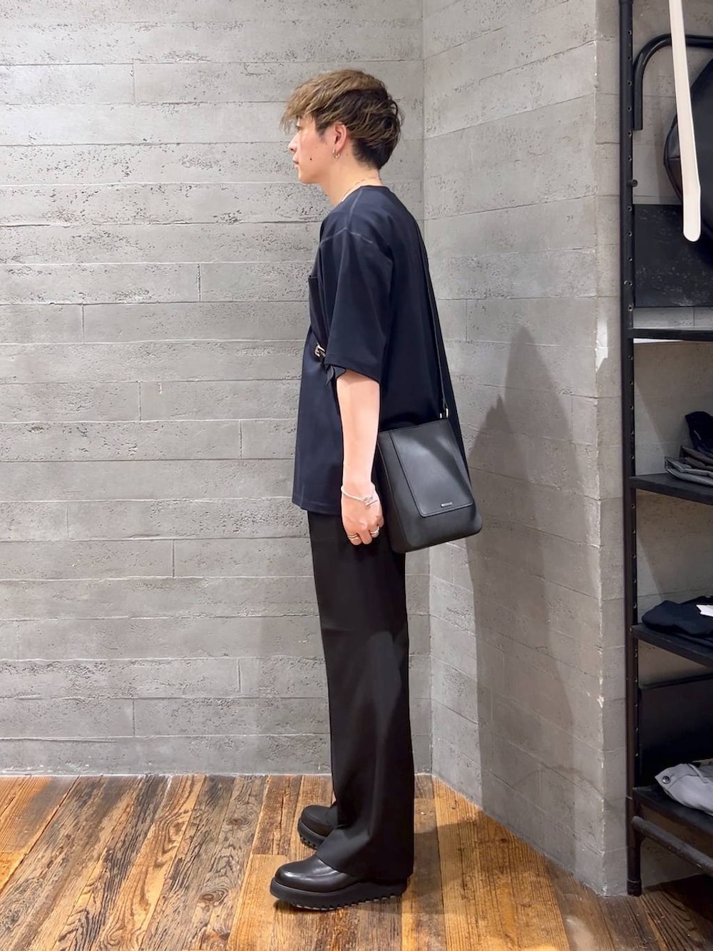 ブラック系のショルダーバッグ、ブルー系のTシャツ/カットソー、ブラック系のドレスシューズを着用したメンズの夏コーディネートの4枚目の写真