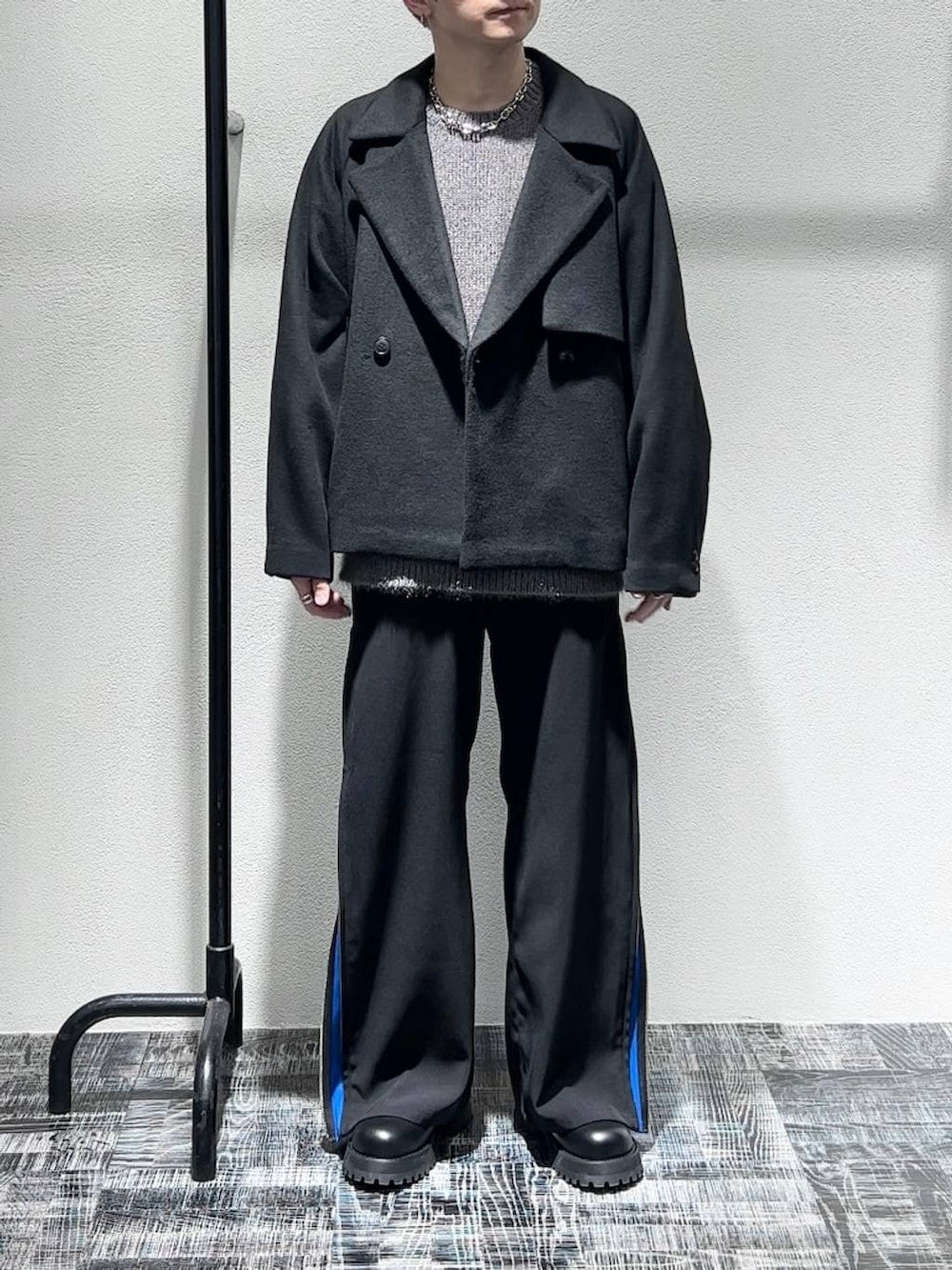 ブラック系のブルゾン、ブラック系のブーツ、ブルー系のスラックスを着用したメンズの秋コーディネートの2枚目の写真