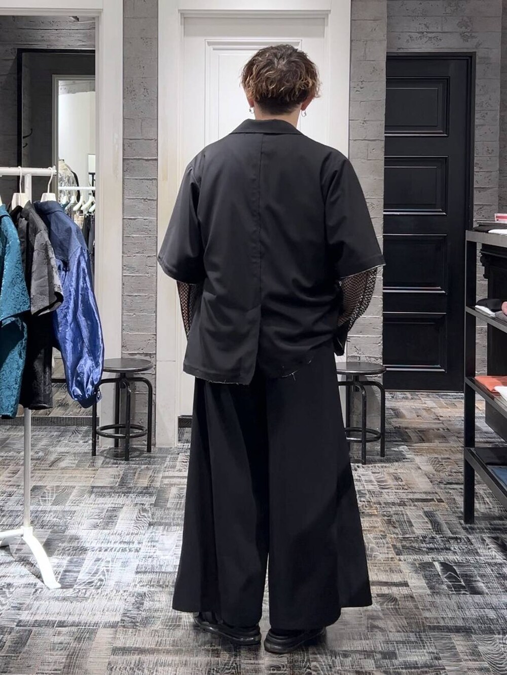 ブラック系のテーラードジャケット、ブラック系のサンダル、グレー系のTシャツ/カットソーを着用したメンズの夏コーディネートの3枚目の写真